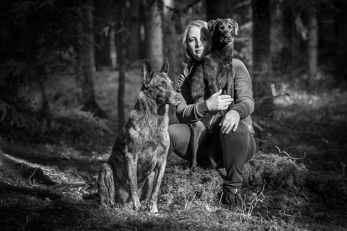 Porträt mit zwei Hunden im Wald